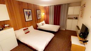 Una habitación de hotel con dos camas y un televisor. en Studio Isola 2000, en Isola 2000