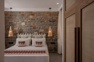 Un dormitorio con una cama y una pared de ladrillo. en Ninemia Villas, en Pláka 49 fotos más