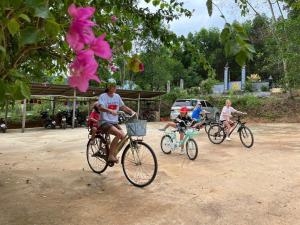 Eine Gruppe von Menschen, die auf einer unbefestigten Straße Fahrrad fahren in der Unterkunft The Farm - Nguyen Shack in Phong Nha