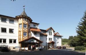 un gran edificio blanco con una torre de reloj en Hotel garni Milseburg, en Hilders