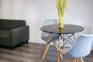 a table with a vase on top of it next to a chair at Les 5 Lys in Carcassonne
