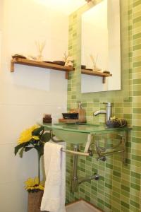 ein grün gefliestes Bad mit einem Waschbecken und einem Spiegel in der Unterkunft Santa Cruz Sunset in A dos Cunhados + 24 Fotos