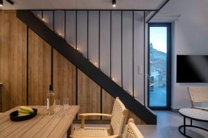 Un comedor con una mesa y una escalera. en Ninemia Villas, en Pláka