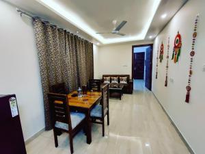 a dining room with a table and chairs and a couch at Heaven Vibes Stays in Rishīkesh