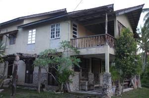 a house with a porch and a balcony at Sepat Village House by the Beach in Kuantan