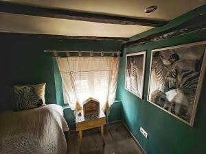 una camera da letto con pareti verdi e un letto con finestra di Casita Singular a Santibáñez de la Peña