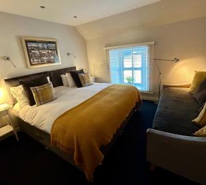 a bedroom with a large bed and a window at Lochindaal Hotel in Port Charlotte
