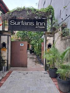 a sign that reads quarters inn on papers on a building at SURFARIS INN on poppies 2 apartment in Legian +2 photos