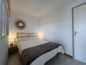 una camera da letto con un letto con uno specchio sul muro di NP060-B08 Appartement 2 pièces 1 chambre, Narbonne Plage a Narbonne-Plage
