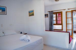 Un dormitorio blanco con una cama con toallas. en Sunlight Kastraki beach house, en Naxos Chora