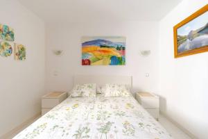 a bedroom with a bed and paintings on the wall at Coqueto apart en Las Coronas in Costa Teguise +33 photos