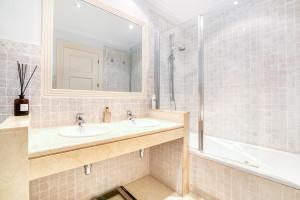 een badkamer met 2 wastafels, een bad en een spiegel bij Gadea 11-2 in Altea +24 foto's