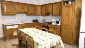 una cucina con mobili in legno e un tavolo con sedie di Au bord de la riviere a Douzy Altre 3 foto