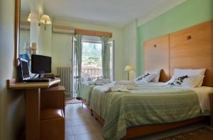 卡蘭巴卡的住宿－凱基斯酒店，一间卧室配有一张床和一张桌子上的笔记本电脑