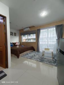 ein Schlafzimmer mit einem Bett und einem großen Fenster in der Unterkunft Trio Gems Condo, Pattaya Thailand in Jomtien Beach + 39 Fotos