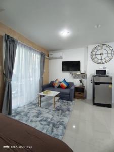 ein Wohnzimmer mit Sofa und Fernseher in der Unterkunft Trio Gems Condo, Pattaya Thailand in Jomtien Beach