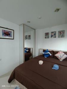 ein Schlafzimmer mit einem braunen Bett und einem Spiegel in der Unterkunft Trio Gems Condo, Pattaya Thailand in Jomtien Beach