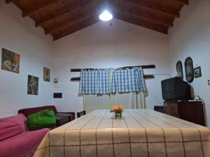 a living room with a table and a couch at Posta Los Reartes in Los Reartes