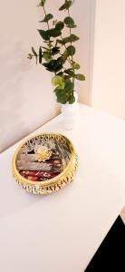 una placa de oro en una mesa con un jarrón en Apartamenty Castello Kamilla, en Kluczbork