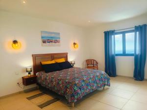 Un dormitorio con una cama y una ventana con cortinas azules. en Villa ALAMANDA - Les Emeraudes du Guillaume, en Saint-Paul 20 fotos más
