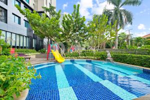 einem Pool mit Rutsche neben einem Gebäude in der Unterkunft Amica by Kozystay - Tanjung Barat in Jakarta