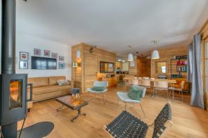 Una sala de estar con un sofá y un comedor. en Appartement Luxe 5 étoiles Parnasse, en Villard-Reculas