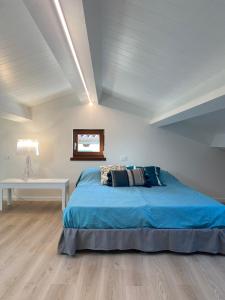 a bedroom with a blue bed and a white table at Delizioso Attico Calle Lunga 2 in Grado