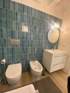 a bathroom with a toilet and a sink and a mirror at Delizioso Attico Calle Lunga 2 in Grado +10 photos