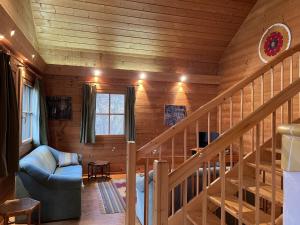 a living room with a staircase in a log cabin at Holiday Home Haus Fries by Interhome in Unterbergern +30 photos