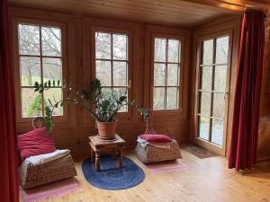 a living room with windows and a potted plant at Holiday Home Haus Fries by Interhome in Unterbergern
