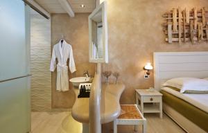 a bathroom with a sink and a bedroom with a bed at Vrahos Boutique Hotel in Karavostasi