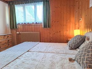 ein Schlafzimmer mit großem Bett und Fenster in der Unterkunft Apartment Rousserolles rez gauche by Interhome in Verbier + 16 Fotos