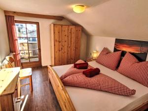 a bedroom with a bed with red pillows on it at Apartment Haflingerhof Edelweiß by Interhome in Kaunertal