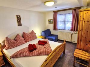 Un dormitorio con una cama grande con almohadas rojas. en Apartment Haflingerhof Enzian by Interhome, en Kaunertal