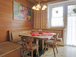 een eetkamer met een tafel en stoelen en een raam bij Apartment Daheim – Wildspitz by Interhome in Plangeross