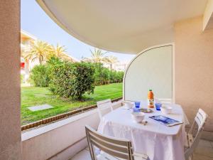 a white table with chairs and a view of a garden at Apartment Le Cesarée-1 by Interhome in Fréjus +18 photos