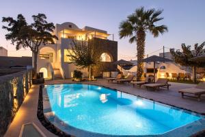 a villa with a swimming pool in front of a house at Santorini Villatzio Suites in Mesaria