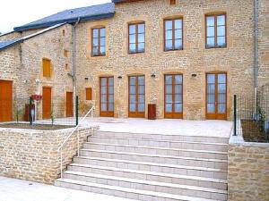 a brick building with stairs in front of it at Le presbytere in Douzy