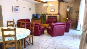 a living room with chairs and a table and a tv at Le presbytere in Douzy