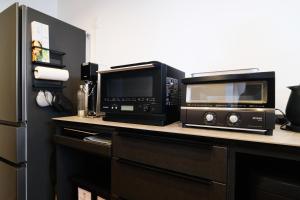 a kitchen with a microwave and a toaster oven on a counter at MIRATIO Sirius in Onna