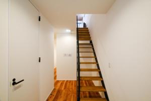 a staircase in a room with white walls and wooden floors at MIRATIO Sirius in Onna