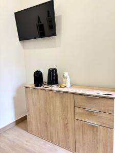 a room with a counter with a tv on the wall at La Suite da Esther in Adrano
