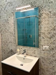 a bathroom with a sink and a mirror at La Suite da Esther in Adrano
