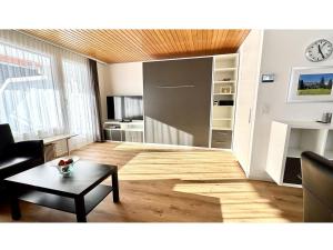 a living room with a table and a clock on the wall at Apartment Sunnmatt West Wohnung 936 by Interhome in Engelberg