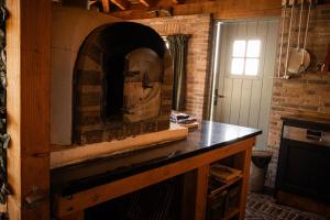 a stone oven in a kitchen with a brick wall at Landgoed Versteegh nabij heerlijkheid Mariënwaerdt in Beesd +20 photos