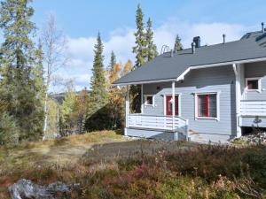 une maison blanche avec des portes rouges dans les bois dans l'établissement Holiday Home Pulkka 3 by Interhome, à Tikkala