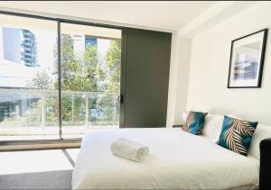 a bedroom with a bed and a large window at Cozy Zetland 2 bedroom apt with pool, gym and parking in Sydney