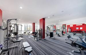 a gym with several treadmills and machines at Cozy Zetland 2 bedroom apt with pool, gym and parking in Sydney