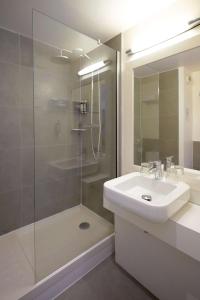 a bathroom with a sink and a glass shower at Best Western Hotel Le Montparnasse in Paris +27 photos