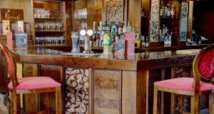 Una barra con dos sillas y un mostrador con alcohol. en Best Western Plus Pastures Hotel, en Doncaster